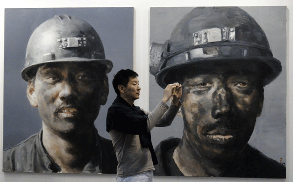 A man snaps a photo at the 2013 Art Beijing Expo in Beijing, on May 1, 2013. Weekly Photos: April 29 - May 5