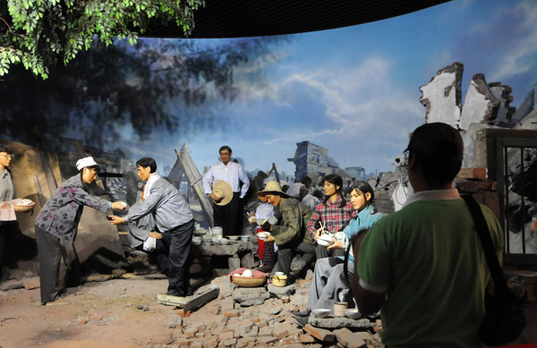 A man looks at a picture that tells the story of post-quake reconstruction at a theme park built to memorialize the fatal earthquake that flattened Tangshan, in the city of North China's Hebei province, on the quake's 35th anniversary, July 28, 2011. Tangshan marks 35 years since fatal quake