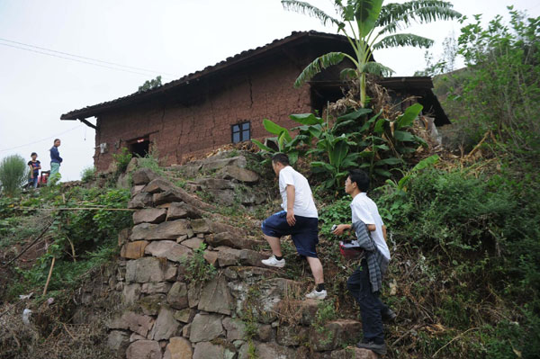 Two volunteers make their way to visit a family in need in Xinlu village, Sept 18, 2011. Motorbike volunteers bring help to kids in need