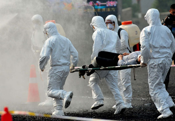 Anti-epidemic workers transfer an infected person during a military exercise in Zunyi, Sept 26, 2011. Air-raid, anti-terror drill staged in SW China
