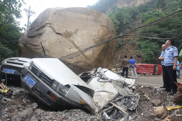 A big rock crushed two cars after falling from a hill, June 6, 2012. 3 injured, 5 cars crushed by falling rocks