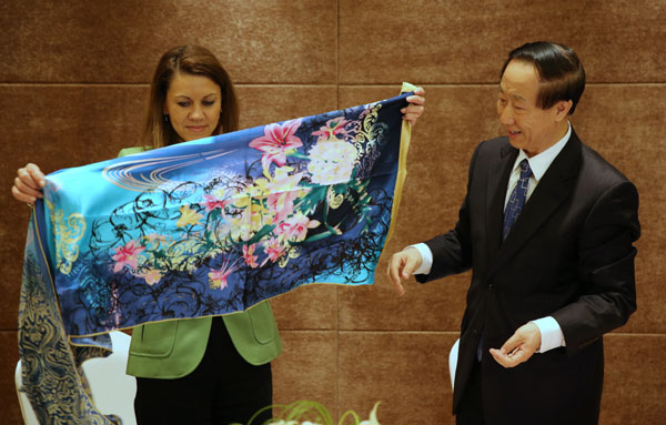 Wang Jiarui, right, gives María Dolores de Cospedal a gift of silk scarves after the meeting in Suzhou, East China's Jiangsu province, April 23, 2013. CPC official meets Spanish party leader