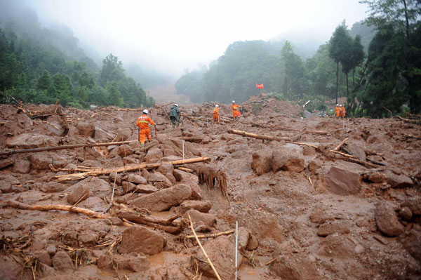 Firefighters search for survivors in Sanxi village, Dujiangyan city, July 11, 2013. Death toll rises to 18 in SW China landslide