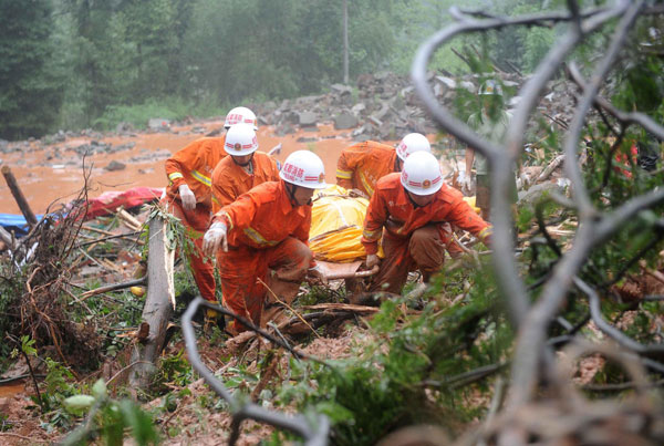 Rescuers find a body from the landslide in Sanxi village, Dujiangyan city, July 11, 2013. Death toll rises to 18 in SW China landslide