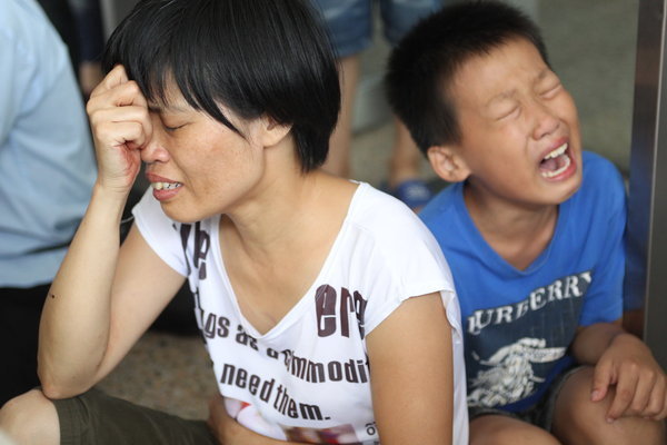 Family members weep for the victims of a knife attack in which people were killed and three injured in Shenzhen, Guangdong province, July 29, 2013. 3 killed, 3 hurt in another random knife attack