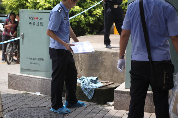 Police investigate the crime scene of a knife attack where people died and three others injured in Shenzhen, Guangdong province, July 29, 2013. 3 killed, 3 hurt in another random knife attack