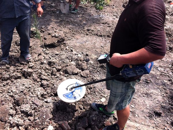 A man looks for ancient coins with a metal locator at the site where large amount of ancient coins were found on Aug 4, 2013 in Jianhu county, Jiangsu province. Villagers make a splash for ancient coins