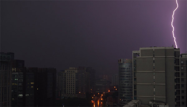 Thunder storm hits Beijing, darkening the sky