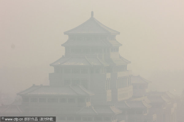 A museum in Zhoukou, Central China’s Henan province, is shrouded by heavy smog, Oct 8, 2013. The bigger temperature difference caused an inversion layer in atmosphere and led to pollution being trapped close to the ground. Henan chokes on lingering smog