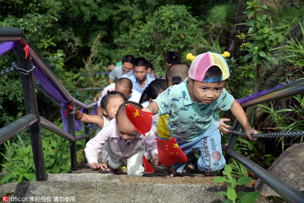 Fathers use bamboo strips to steer children on cliff walkway