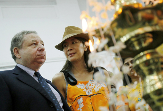 Jean Todt and Michelle Yeoh light an oil lamp at a vintage car rally