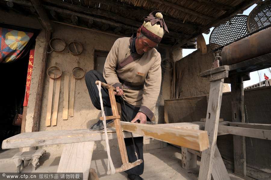 Chen Jianhua, a craftsman, makes a flour sifter at his shop in China West Film Studio, Ningxia Hui autonomous region, on March 16, 2012. Making flour sifter now a craft of the past