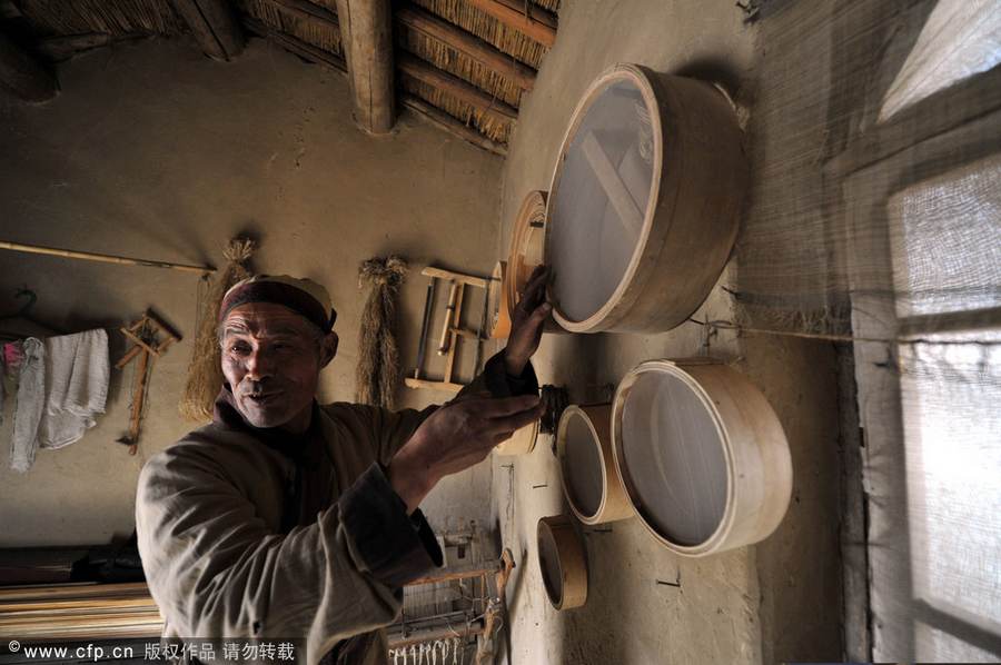 Chen Jianhua, a craftsman, makes a flour sifter at his shop in China West Film Studio, Ningxia Hui autonomous region, on March 16, 2012. Making flour sifter now a craft of the past