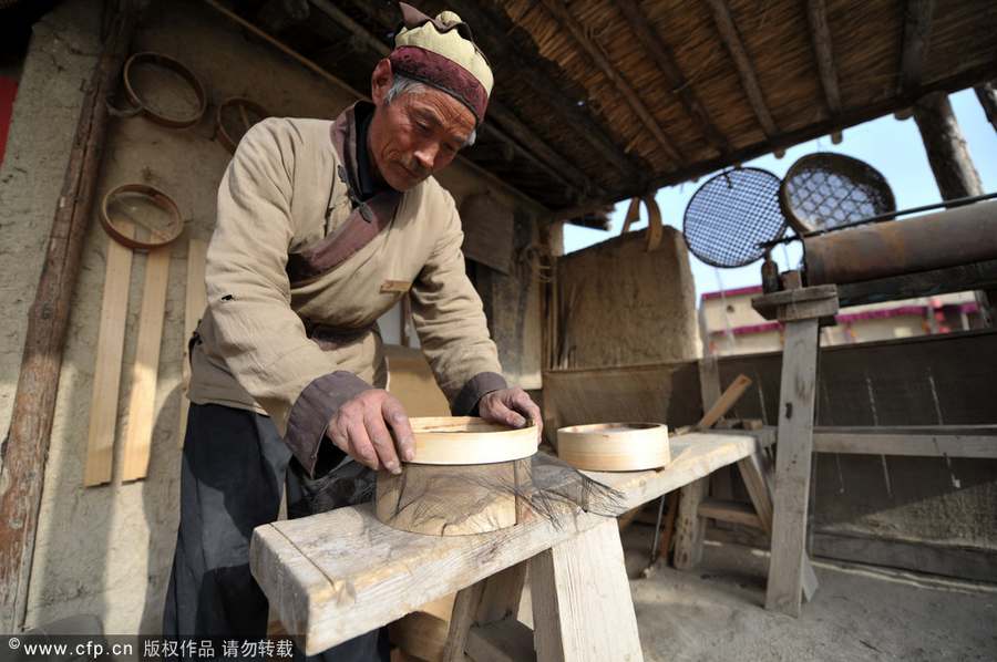 Chen Jianhua, a craftsman, makes a flour sifter at his shop in China West Film Studio, Ningxia Hui autonomous region, on March 16, 2012. Making flour sifter now a craft of the past