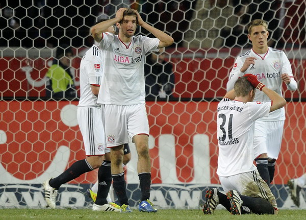 Bayern Munich's Thomas Mueller (L) and Bastian Schweinsteiger (2nd R) react after their German Bundesliga first division soccer match against Hanover 96 in Hanover, Oct 23, 2011. Levante stay ahead, Bayern concedes first goal