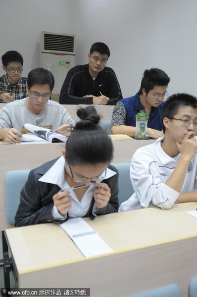 Yao takes notes in a history class at Shanghai Jiaotong University on Nov 7, 2011. Yao Ming becomes management-school freshman