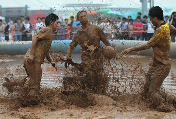 Players compete on Friday in the Chinese leg of the British Mud Soccer Cup in Beijing's Olympic Park. The event attracted 32 teams. Photo by Wang Jing / China Daily Mud Soccer Cup in Beijing
