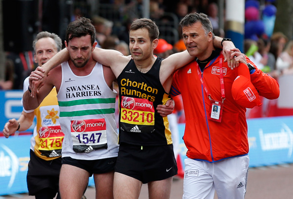 London Marathon runner carried over line by fellow runner