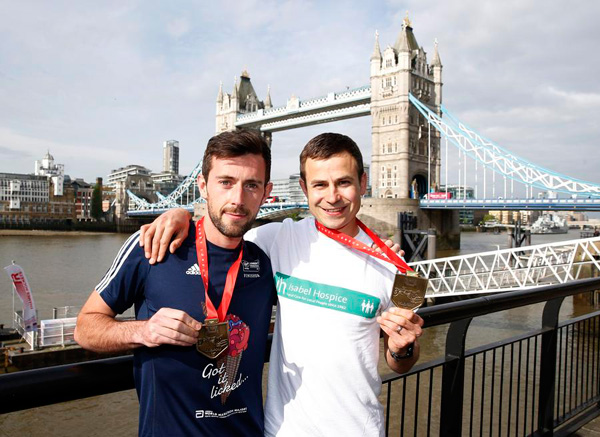 London Marathon runner carried over line by fellow runner