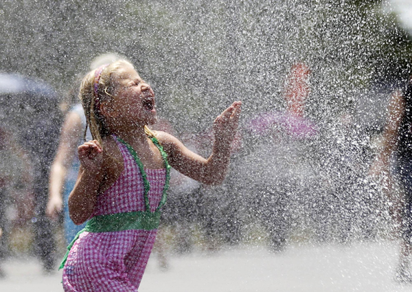 Children play with sprays of water in Washington