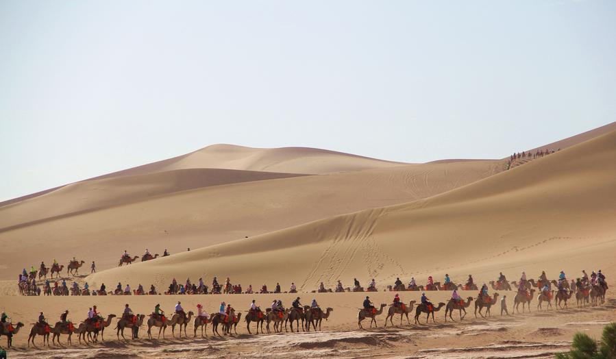 Tourists visit Mingsha Mountain in Dunhuang