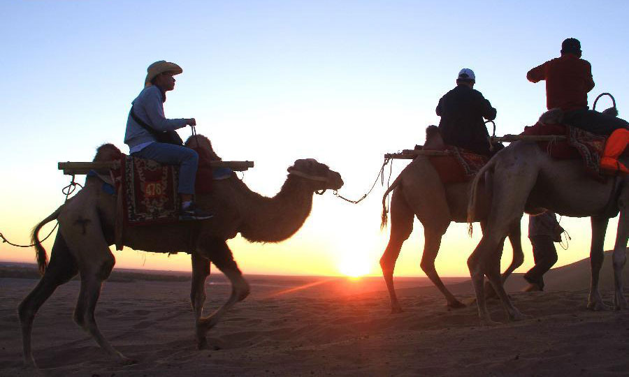 Tourists visit Mingsha Mountain in Dunhuang