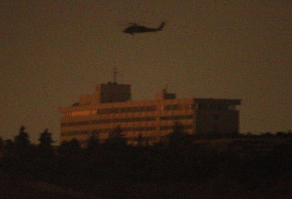 A NATO helicopter flies above the Intercontinental hotel in Kabul June 29, 2011. Police search Kabul hotel after Taliban kills 10