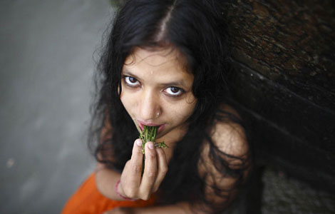 A woman lashes herself with the leaves of the Aghada plant at the Bagmati River, during the Rishi Panchami festival, in Kathmandu Sept 20, 2012. - 0013729e431911c4ec6312