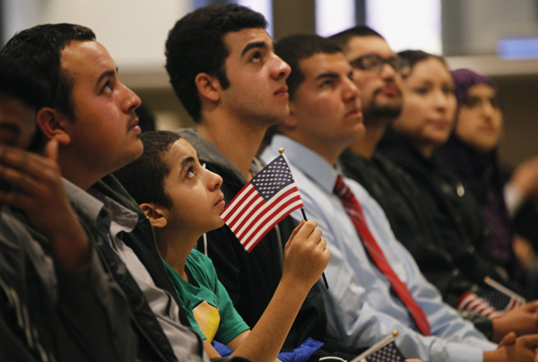 Mohamed Farag, 12, is joined by adults while watching a video after receiving proof of US citizenship in San Francisco, California, Jan 30, 2013. US immigration overhaul possible by 1st half of 2013