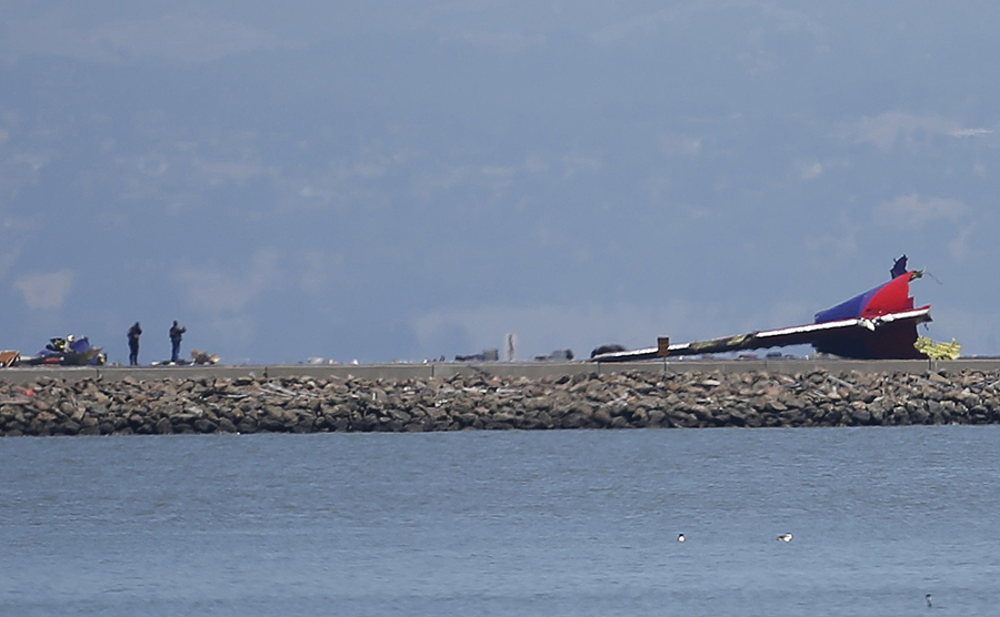 The tail section of Asiana Airlines flight 214 sits on the runway at San Francisco Airport International Airport on July 6, 2013. The plane, with 307 people on board, crashed and burst into flames as it landed at San Francisco International Airport on Saturday after a flight from Seoul, and initial reports said two people were killed and more than 130 sent to hospitals. Asiana flight crashed at SFO