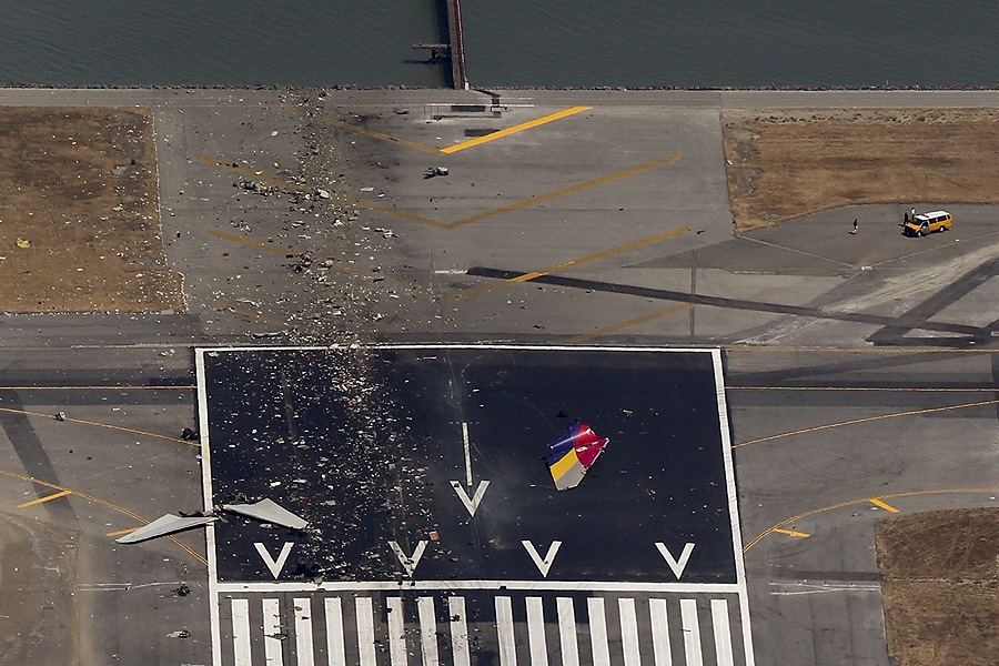 Debris from an Asiana Airlines Boeing 777 plane is seen on a runway after it crashed while landing at San Francisco International Airport in California on July 6, 2013. The plane, with 307 people on board, crashed and burst into flames as it landed at San Francisco International Airport on Saturday after a flight from Seoul, and initial reports said two people were killed and more than 130 sent to hospitals. Asiana flight crashed at SFO