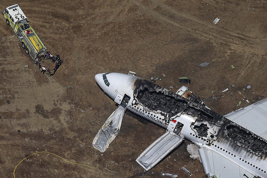 Rescue officials stand near an Asiana Airlines Boeing 777 plane after it crashed while landing at San Francisco International Airport in California on July 6, 2013. Two people were killed and 130 were hospitalized after the plane crash-landed at San Francisco International Airport on Saturday morning, San Francisco Fire Department Chief Joanna Hayes-White said. The figures cited by Hayes-White leave 69 people still unaccounted for in the accident. The Boeing 777, which had flown from Seoul, South Korea, was carrying 307 people. Asiana flight crashed at SFO