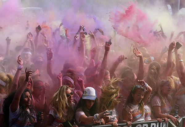 Participants throw coloured paint into the air after finishing The Color Run outside Wembley Stadium in London, July 14, 2013. The Color Run is a five kilometre, un-timed race, held in cities across the US and also worldwide, with the aim of promoting healthy living, and the organizers choose a charity to benefit in each of the cities the run visits. Participants are doused from head to toe in different colours at each kilometre. Color Run in London promotes healthy living