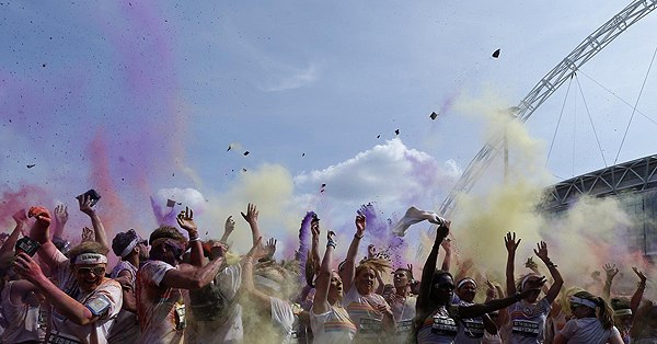 Participants throw coloured paint into the air after finishing The Color Run outside Wembley Stadium in London, July 14, 2013. The Color Run is a five kilometre, un-timed race, held in cities across the US and also worldwide, with the aim of promoting healthy living, and the organizers choose a charity to benefit in each of the cities the run visits. Participants are doused from head to toe in different colours at each kilometre. Color Run in London promotes healthy living