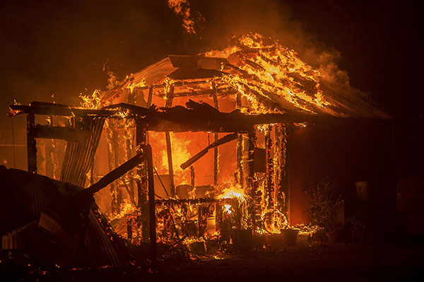 Thousands flee California wildfire as homes go up in flames