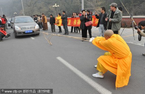 Buddhist nun shows off her strength pulling cars