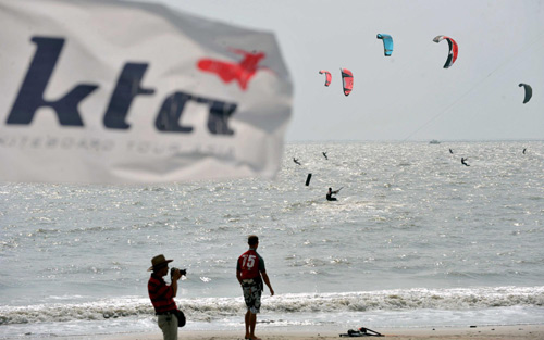 Kite surfers ride the waves in S China