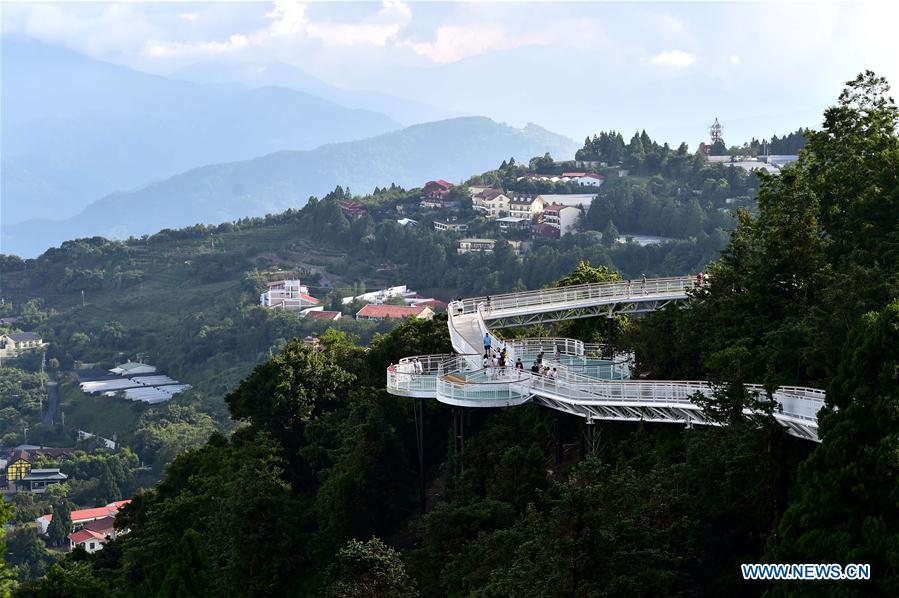 People enjoy scenery at high altitude sight-seeing footpath