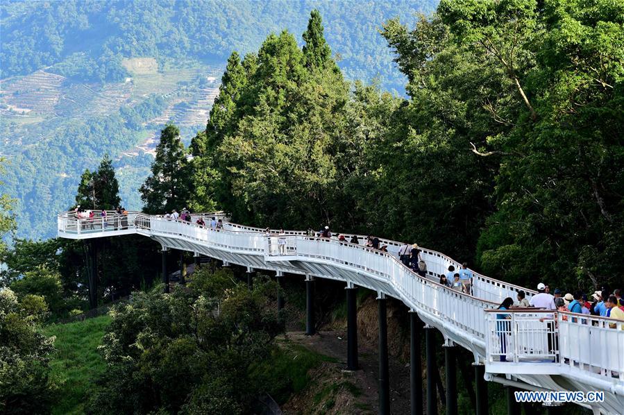 People enjoy scenery at high altitude sight-seeing footpath