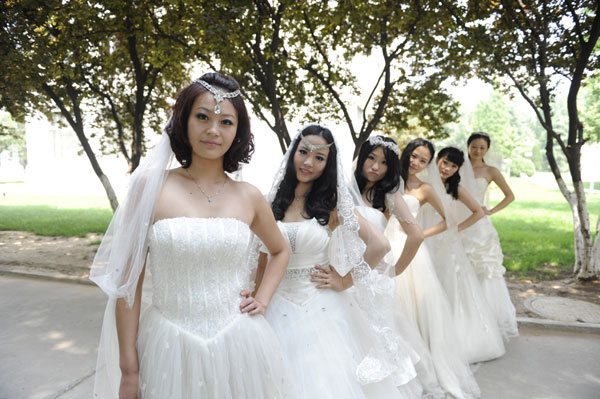 Graduates in wedding gowns honor college years