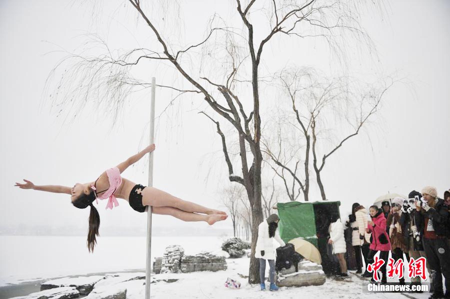 Pole dancers parctices outside in cold winter