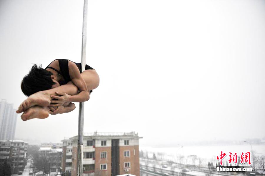Pole dancers parctices outside in cold winter
