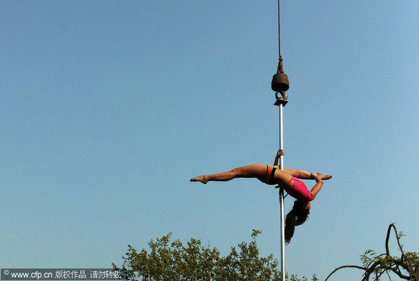 Crane hoists pole dancers in air