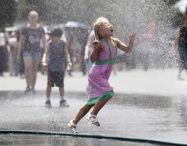 Children play with sprays of water in Washington