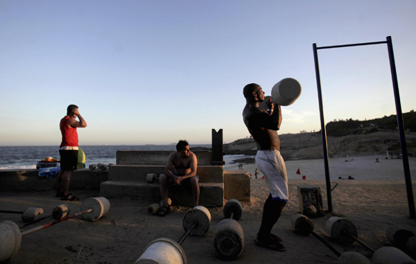 Men work out using cement-made weights