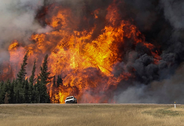 Canada wildfire rages near oil sand facilities, extending shutdowns